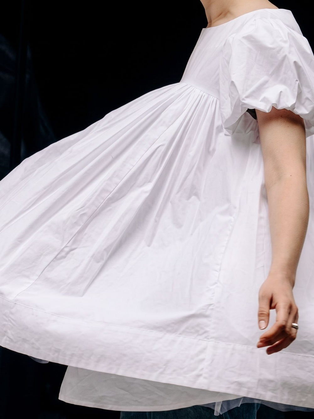 A person spinning in her white baby doll top.